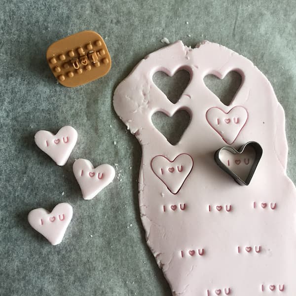 cutting out conversation hearts from sugar dough