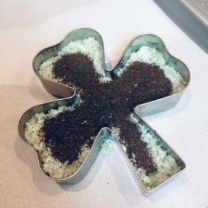 a shamrock shaped cookie cutter with epsom salt and black tea